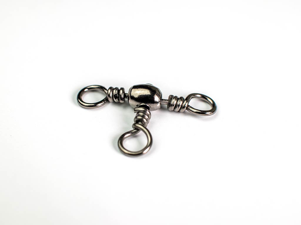 A metal, three-way swivel used for fishing against a white background