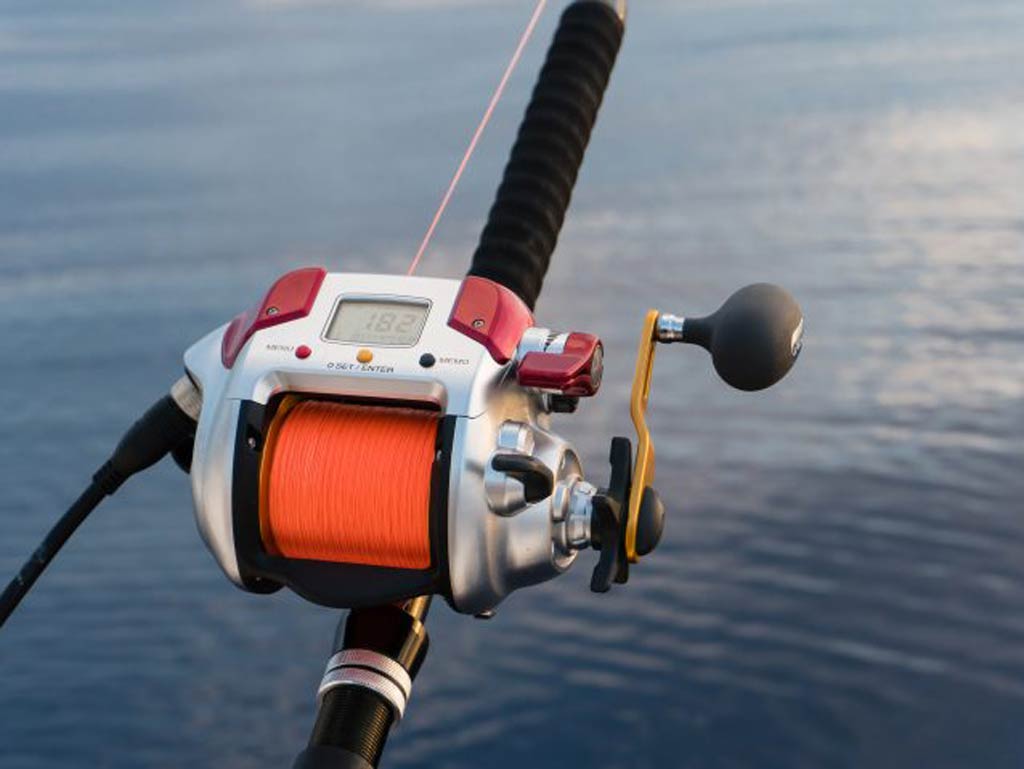 A photo of an electric deep dropping fishing reel with red fishing line