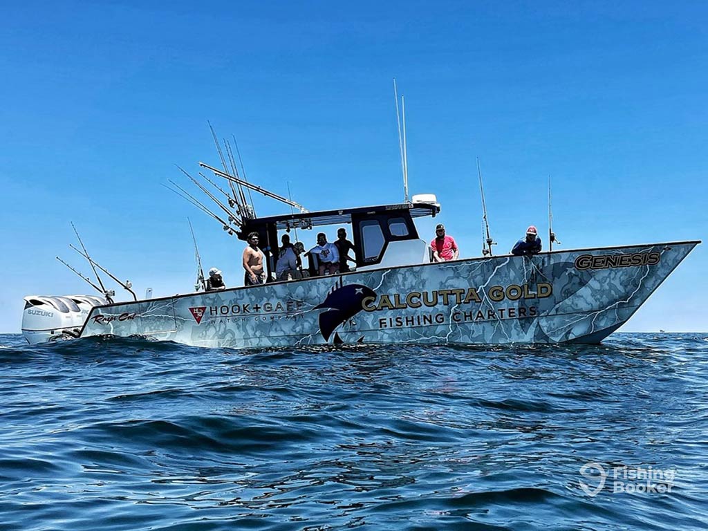 A view across the water towards the side of a center console fishing bopat, rigged up for trolling in the Gulf of Mexico on a clear day